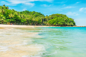 Fototapeta premium Freedom beach on Phuket island, Thailand with nobody. Tropical beach with crystal clear waters, sandy shore, palm trees and green foliage under blue sky. Summer and winter vacation destination