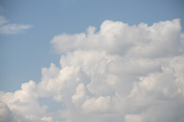 White cumulus clouds look large against the blue sky.