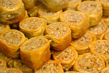 Close-up view of baklava with pistachios, walnuts and cream in a dessert shop selling traditional Turkish desserts. Ş&ouml;biyet, nightingale's nest, bird's eye baklava. Turkish culinary delights. Dessert 