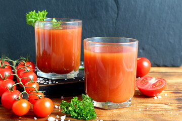 Two glasses of tomato juice are on the table.