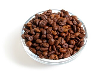  There is a glass cup with coffee beans on a white background.