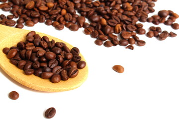 On a white background lies a wooden spoon with coffee beans.	