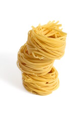 On a white background there is a stack of three macaroni in the form of a nest.