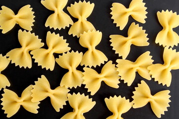 Background of pasta lying on a black stone background.	