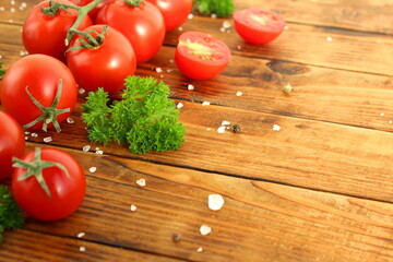There is a fresh harvest of cherry tomatoes on a wooden table.