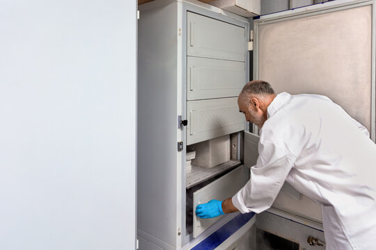 Scientist accessing cryogenic laboratory freezer. - Powered by Adobe