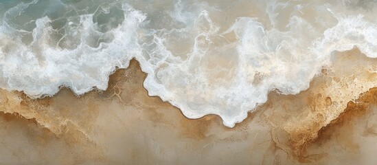 Obraz premium Aerial view of sandy beach with gentle waves lapping at the shore creating a serene coastal landscape