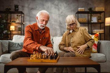 senior couple husband and wife play leisure chess board game at home