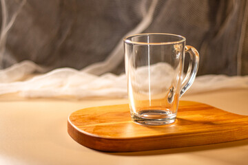 Empty transparent cup on wooden tray. Mock up for design. Served table. Preparation for making drink