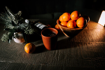 Enjoying a Cozy Evening With Craft Mulled Wine and Fresh Tangerines on a Wooden Table During Winter Celebrations