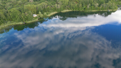 Reflets du ciel et des nuages sur le lac de Chavoley, sur la commune de Ceyzérieu, dans l'Ain en France à la fin du printemps