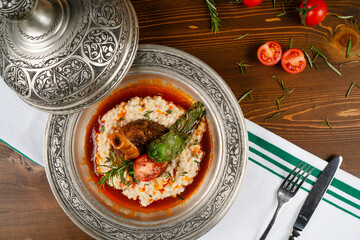 Traditional Turkish cuisine dish Lamb Shank with sauce. Lamb shank served elegantly on a copper plate.
