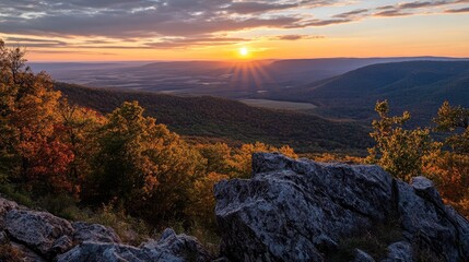 Majestic sunrise illuminating a vibrant mountain landscape with colorful foliage and rock formations at the peak of a serene vista.