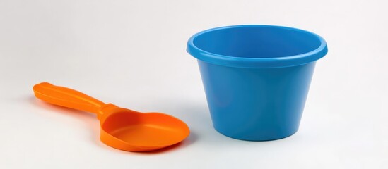 Colorful beach sand toys featuring a blue bucket and an orange shovel on a white background ideal for summer activities and children's play.
