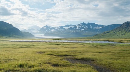 Obraz premium Stunning panoramic view of Kaldnasi mountain and Rjomafoss surrounded by lush greenery in the West Iceland landscape under a clear sky.