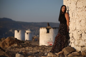 Fototapeta premium A joyful young Asian woman embraces the breathtaking beauty of her surroundings during the golden hour. 