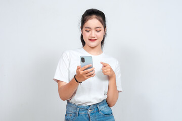 A portrait of a cheerful Asian woman looking at her smartphone over white background