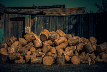 Logs in front of a wooden building marked with the number 21