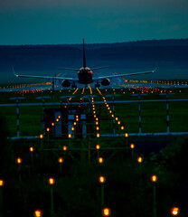 A commercial airplane is taking off from an airport runway during the night