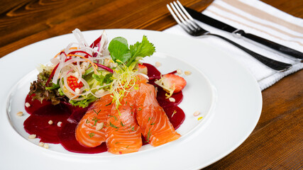 Fresh salmon fillet. A delicious portion of salmon fillet garnished with aromatic herbs and radish. Healthy dinner.