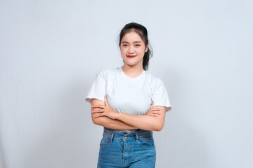 Portrait of a confident smiling girl standing with arms folded and looking at the camera isolated...