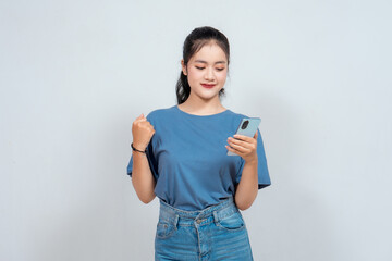 A young Asian woman with a happy successful expression with holding smart phone