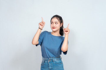 Excited Asian woman pointing at the copy space beside her, isolated on white background
