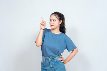 Excited Asian woman pointing at the copy space beside her, isolated on white background