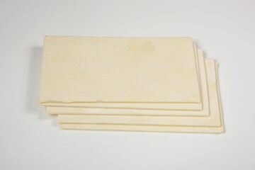 raw yeast pastry slices on a white background with spices. Flat dough plates. puff pastry. puff...