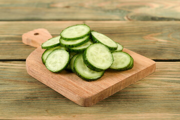 Close-up of fresh cucumber sliced into rings on a cutting board.