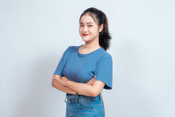 Portrait of a confident smiling girl standing with arms folded and looking at the camera isolated...