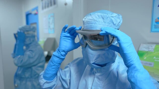 Pharma worker wearing goggles. PPE kit wearing for protection from bio hazardous chemicals. pharmaceutical scientist employee wearing eye cover gear in a cleanroom.