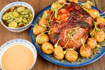 Baked meat with baby potatoes, mini green sprouts and cucumber sauces.
