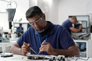 Engineer Soldering Electronic Components in Lab
