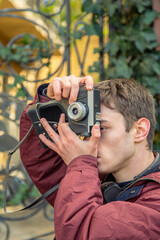 A young man takes pictures on a vintage camera. Film camera photography.