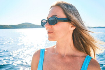 Beautiful woman relaxing outdoors on the beach on a summer day. I wear a wide-brimmed hat and sunbathe with UV protection. Beach holiday concept.