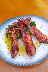 grilled calamari with potatoes and spinach on a plate. Traditional Croatian food