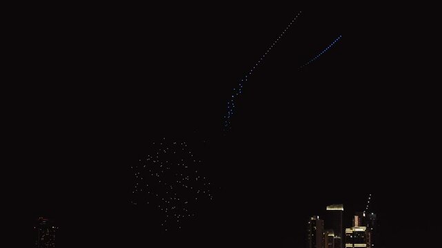 Drone show in night sky over Bluewaters and JBR Beach promoting Dubai Shopping Festival. Taken from hands. High quality 4k footage
