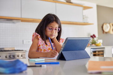 Little indian girl studying on digital tablet
