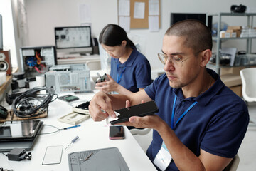 Obraz premium Engineers Assembling Electronic Device Inside Office Setting