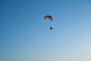 Paraglider soaring in a clear blue sky
