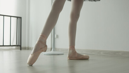 Ballet dancer practicing in studio with soft lighting and wooden floor © JR-50