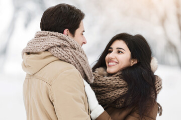 Winter Date. Loving Husband And Wife Hugging Standing Declaring Their Love In Snowy Park Among Trees Covered With Snow