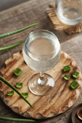 A glass of natural aloe vera juice with fresh green aloe vera leaves