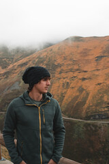 Naklejka premium Man in Mountain Landscape with Autumn Colors and Fog