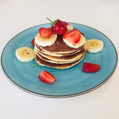 pancakes with strawberries in a blue plate