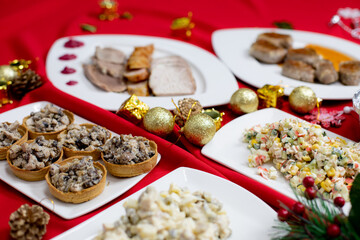 Savory tartlets filled with creamy mushroom and meat mixture, elegantly arranged on a white plate on a festive table with Christmas decorations.
