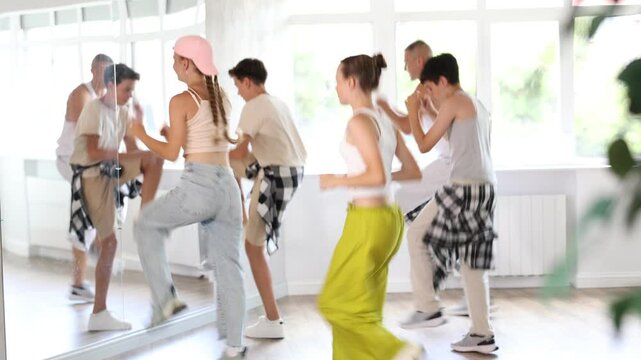 Group of young girls an boys perform choreographic exercises and teaches energetic breakdancing waacking together 