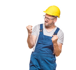 Excited middle-aged construction worker with clenched fists, isolated on white background. Yes concept. Good news. Copy space. Rejoicing repairman celebrates success. Craftsman against white wall