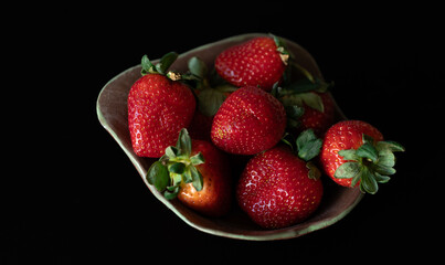 Strawberry on plate with black background